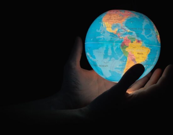 blue and brown globe on persons hand